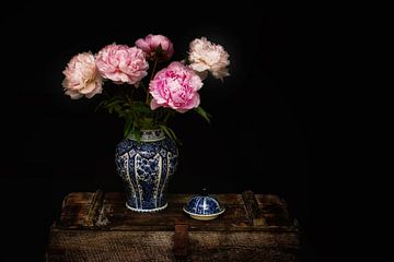 Vase bleu de Delft avec des pivoines sur un coffre vintage sur marlika art