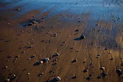 Gouden zand, ingewijd door de ondergaande zon, door de zee, nat van de eb en vloedgolf. Textuur Voet