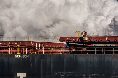 Bulkcarrier in de haven en stoomwolken van de kade