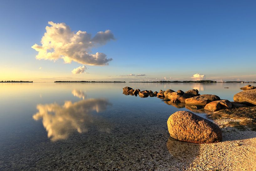 Cloud over IJsselmeer with breakwater of boulders by FotoBob