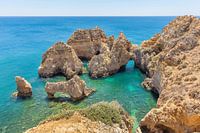 Rocks in blue sea on the coast in the Algarve Portugal