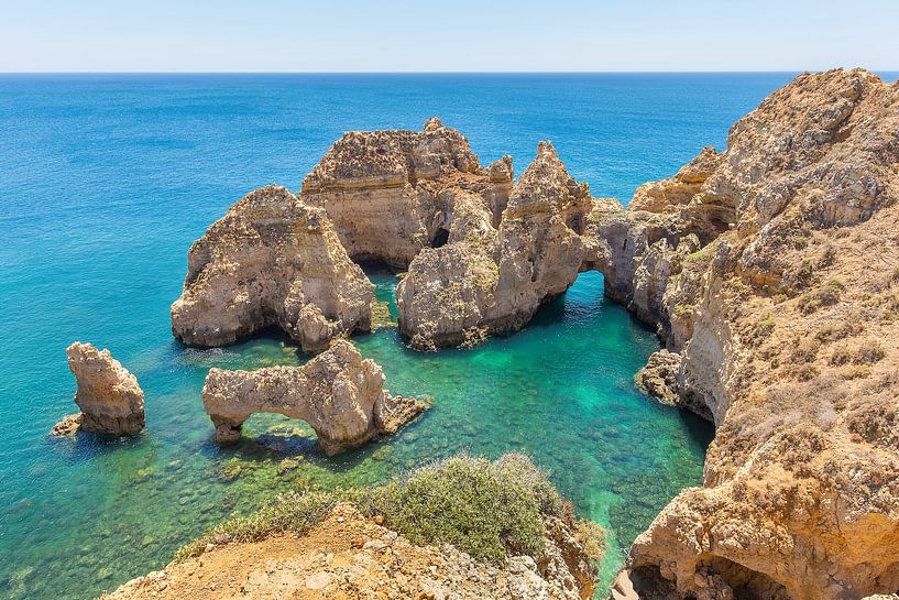 Felsen im blauen Meer auf der Küste in der Algarve Portugal von Ben Schonewille