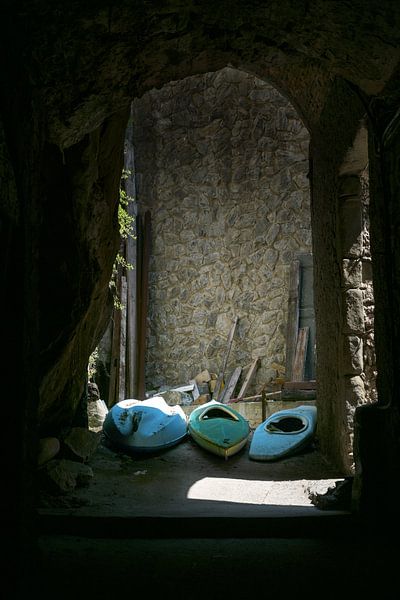 Three old rowboats in a dark alley in an historic seaport town, Liguria, Italy, copy space by Maren Winter