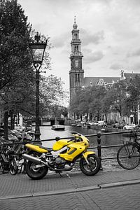 Gelbes Motorrad und Fahrräder parkten neben einem Kanal in Amsterdam
