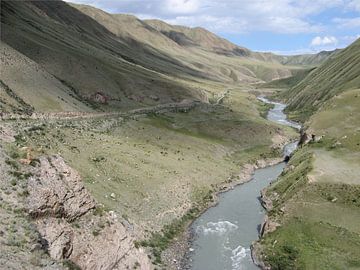 Bergweg langs rivier in Kirgizië van Toon Loonen