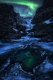 Frozen waterfall on aurora borealis night in Iceland by Daniel Gastager