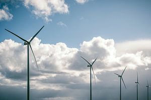 Windkraftanlagen mit blauem Himmel und weißen Wolken im Hintergrund