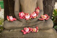 Bloemen op schoot bij Boeddhabeeld van Marja van Noort thumbnail