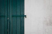 Grün-blaue Fensterläden mit weißer Wand auf der Île de Ré - Frankreich
