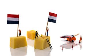 Miniaturpuppen legen Flagge auf Käse