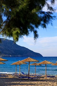 Sonnenschirme aus Weidengeflecht an einem Strand in Karpathos von Laura V