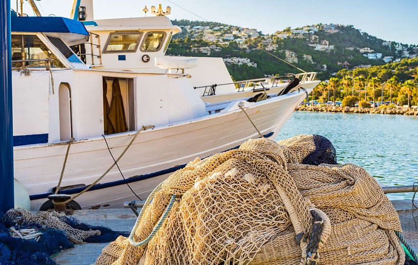 Old fishing trawlwer and heap of fishing net at harbour by Alex Winter