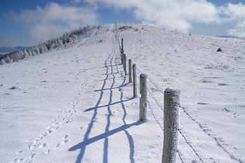 Een weideomheining in de winter langs een besneeuwd bergpad. Lachtal, Stiermarken