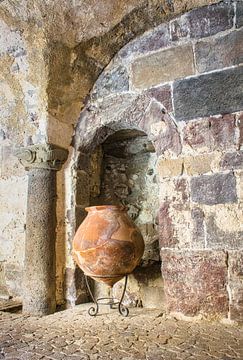 Big pitcher on standard against ancient wall by Rietje Bulthuis