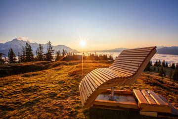 Een houten ligstoel in het licht van de opkomende zon van Christa Kramer