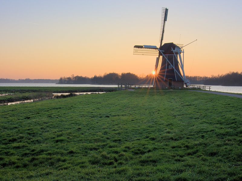 Windmill at lake by Hannon Queiroz