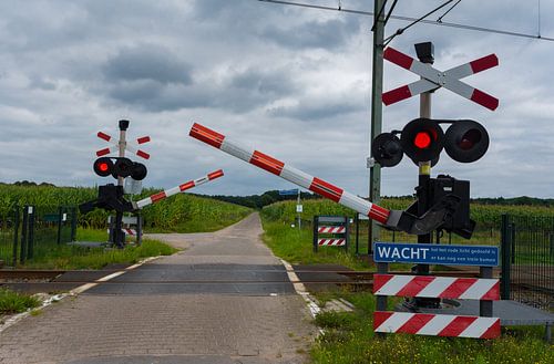 Spoorwegovergang -wacht er komt een trein.