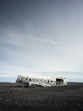 Flugzeugwrack auf der kargen dunklen Ebene von Sólheimasandur in Island von Teun Janssen
