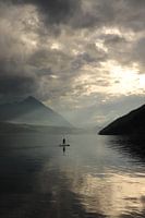 Paddelboarder auf dem See nach Regen.