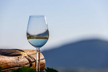 Gevuld wijnglas naast houten balk van Reiner Conrad