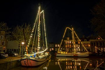 Versierde traditionele boten in Harlingen bij avond in Nederland van Eye on You