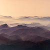 zonsondergang boven mistige bergen van Gerard Wielenga