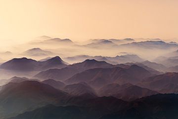 zonsondergang boven mistige bergen van Gerard Wielenga
