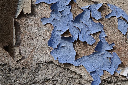 Afbladderende verf op een vervallen gevel