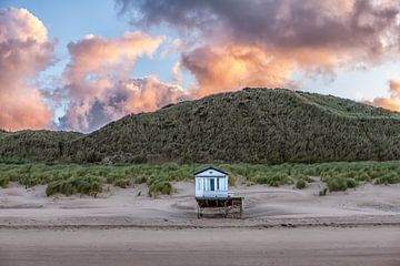Strandhaus am Strand mit der aufgehenden Sonne an der Nordseeküste in Zeeland gegen eine rosa orange von Wout Kok