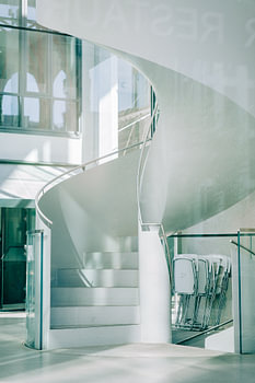 Curved spiral staircase in a light-coloured interior