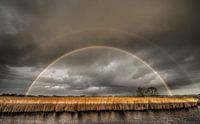 Regenboog achter IJsselmeerdijk van Harrie Muis thumbnail