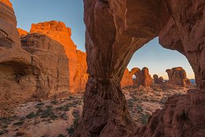 Blick auf den Doppelbogen bei Sonnenaufgang, gesehen vom Cove Arch, Arches Nationalpark.