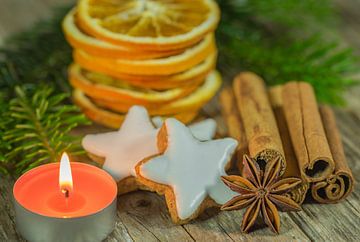 Kerstcompositie van sterrenkoekjes, specerijen, sinaasappelschijfjes en kaarslicht van Alex Winter