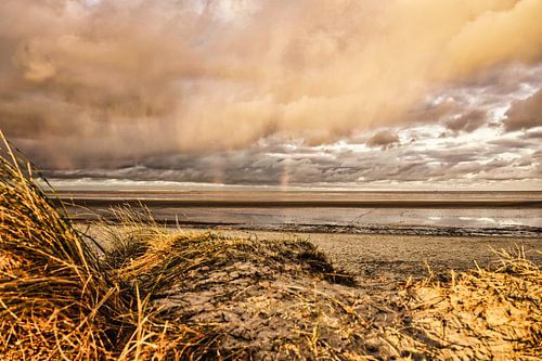 Zonsondergang en regen - een regenboog boven de Waddenzee