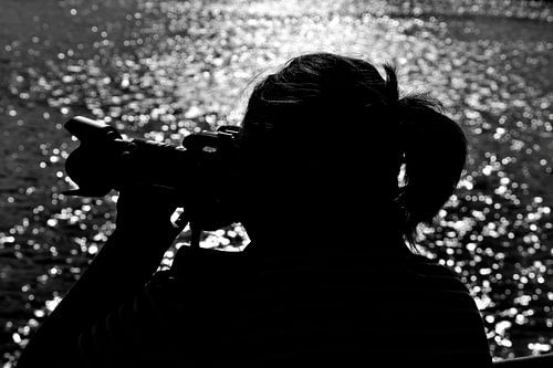 Silhouette van een fotograferende vrouw