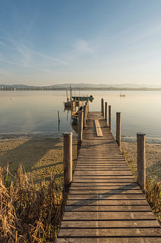 Holzsteg und Fischerboote am Bodensee im Morgenlicht - Halbinsel