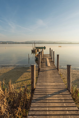 Wooden jetty and fishing boats on Lake Constance in the morning light – peninsula