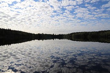 Wolkenluchten boven een meer in Zweden van Antoon Loomans