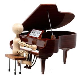 Wooden figure playing mini piano by Hans-Jürgen Janda