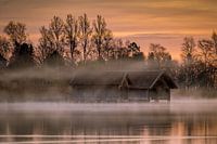 Bootshuizen in de mist aan de Kochelsee