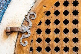 Wooden door with an ornate hinge by Dieter Walther