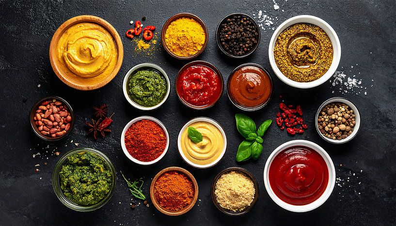 Range of colourful spices and sauces, including turmeric by Mustafa Kurnaz
