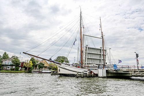 Tweemast zeetjalk door brug van Warns