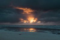 Zonsondergang met een donkere wolkenlucht bij Terschelling