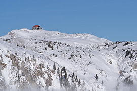 Refuge de montagne sur un sommet enneigé, sous un ciel dégagé sur Tomherkules