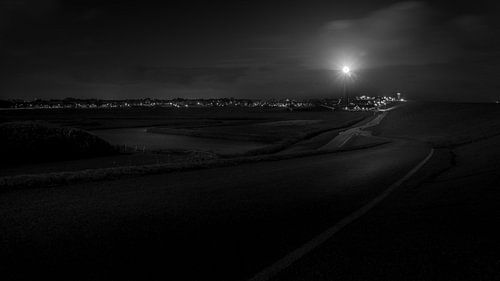 Black and white photograph of a lighthouse at night.