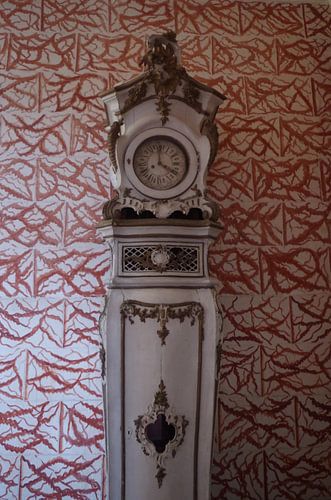 Standing clock against white-red wallpaper