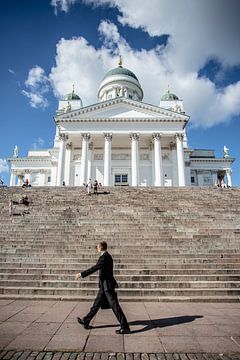 Helsinki, man met koffertje loopt langs de domkerk