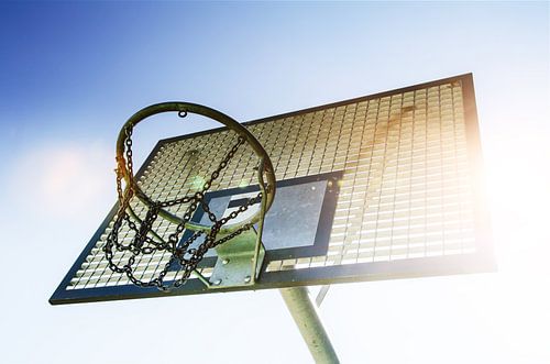 Basketbalring met kettingnet in het zonlicht