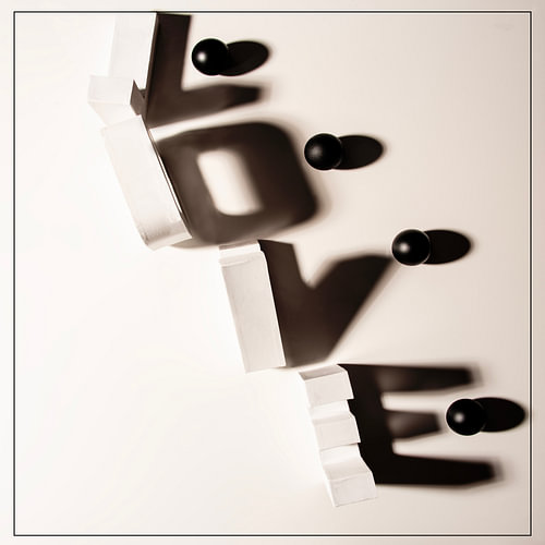 LOVE – mit Schatten aus weißen Buchstaben und bunten Würfeln. von Gerhard de Wit